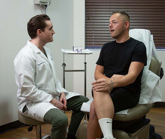 Michael McBride, DO, consults with a patient about treatment